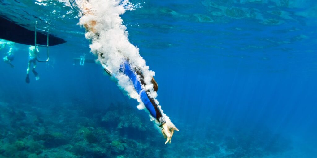 Person diving into clear blue water.